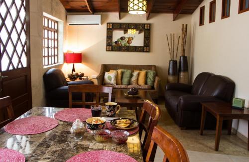 - un salon avec une table et un canapé dans l'établissement Bed and Breakfast Pecarí, à Cancún