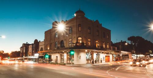 a building on the corner of a street at night at Crown Hotel Surry Hills in Sydney