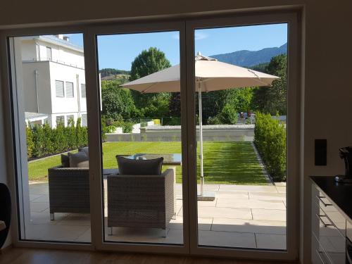 an open patio door with an umbrella and chairs at Zegg-Lounge in Seeboden