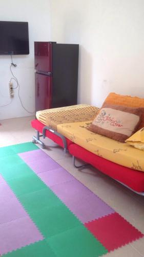 a bedroom with a bed and a colorful rug at Olivine House in Bandar Lampung