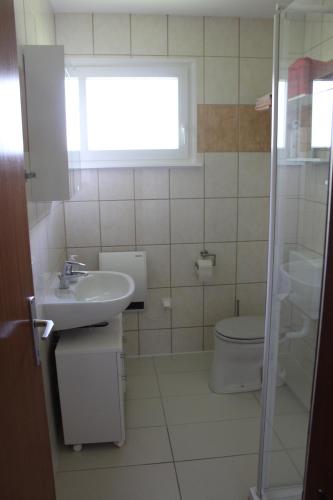 ヴァイセンゼーにあるFerienhaus Seeliebeのバスルーム(洗面台、トイレ付)、窓が備わります。