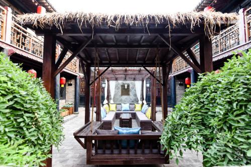 a pavilion with a table and some plants at Elsewhere Hotel The former residence of the draft bank in Pingyao