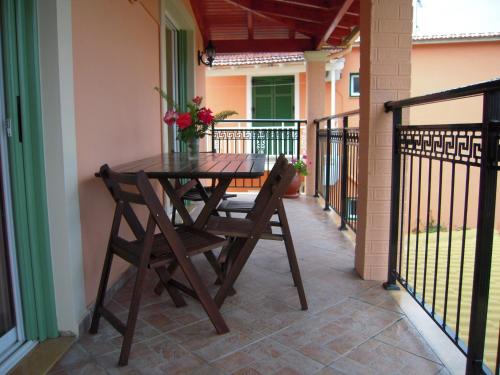 a wooden table and chairs on a balcony at Villa Pepy in Mesongi