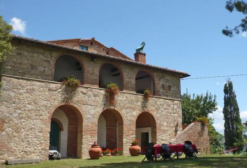 un edificio de ladrillo con dos caballos delante de él en Agriturismo Caio Alto, en Cetona