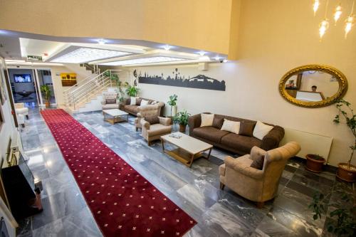 a living room with couches and a red rug at Business Han Hotel in Nevsehir