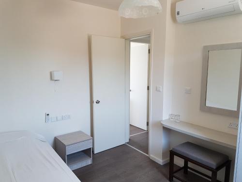 a bedroom with a bed and a desk and a mirror at Aphrodite Beach Hotel in Polis Chrysochous