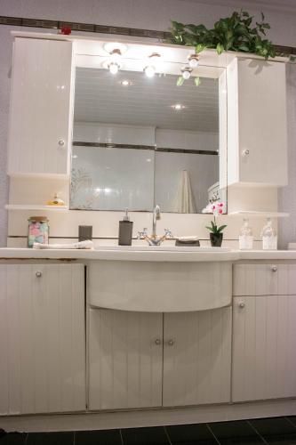 a kitchen with a sink and a mirror at Alexandra Villa Stalos in Stalos