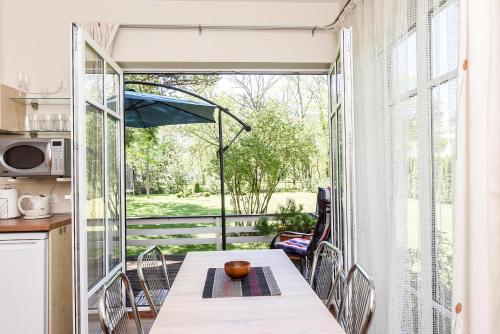 eine Küche und ein Esszimmer mit einem Tisch und einem großen Fenster in der Unterkunft Vila Claudia in Palanga