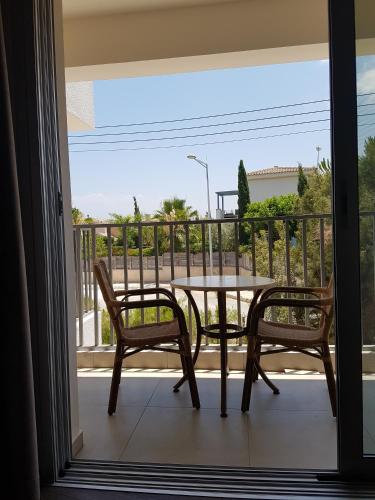 a table and two chairs on a balcony at Aphrodite Beach Hotel in Polis Chrysochous