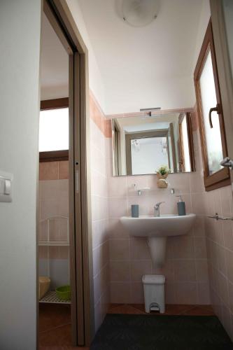 サンタンティーオコにあるAppartamento Lavandaのバスルーム(洗面台、鏡付)