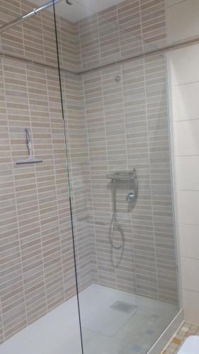 une douche avec une cabine en verre dans une salle de bain dans l'établissement la ferme au ROY, à Bernouil