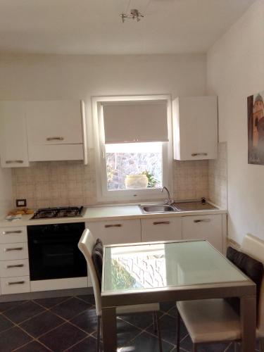 a kitchen with a table and a sink and a window at Costa Morroni in Levanto