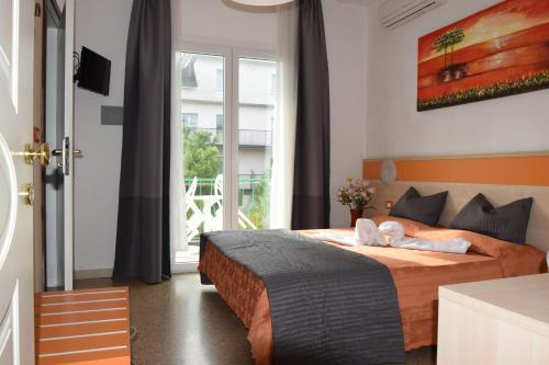 a bedroom with a bed and a large window at Hotel Verdi in Lido di Jesolo