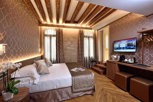 a bedroom with a bed and a flat screen tv at Rosa Salva Hotel in Venice