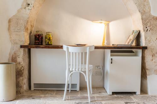 a desk with a white chair in a room at Borgo Canonica in Cisternino