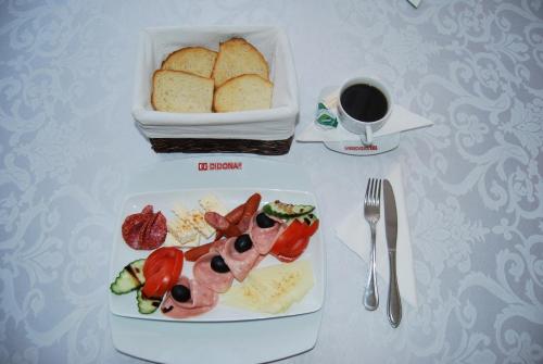 une table avec une assiette de nourriture et une tasse de café dans l'établissement Motel Didona B, à Galaţi