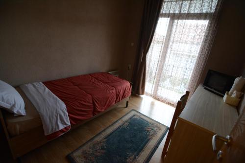 a small bedroom with a bed and a window at Guest House Via in Bitola