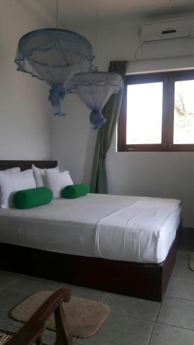 a bedroom with a large bed with a window at KANDY Holiday Residence in Kandy