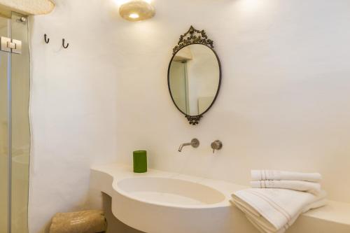a white bathroom with a sink and a mirror at Borgo Canonica in Cisternino