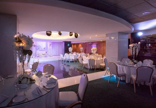 a banquet hall with white tables and white chairs at Amman International Hotel in Amman