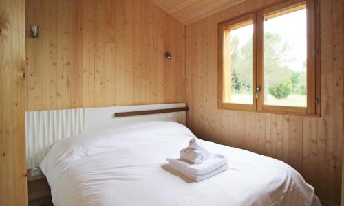 sypialnia z łóżkiem z białą pościelą i oknem w obiekcie Les Chalets Montréjeau w mieście Montréjeau