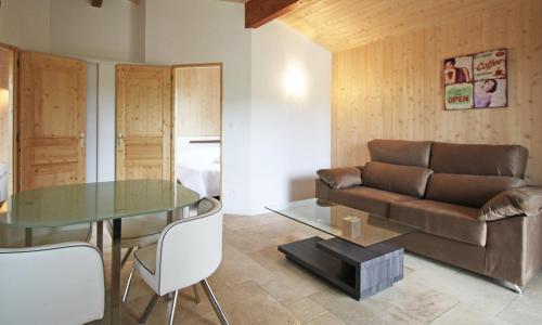 un salon avec un canapé et une table en verre dans l'établissement Les Chalets Montréjeau, à Montréjeau