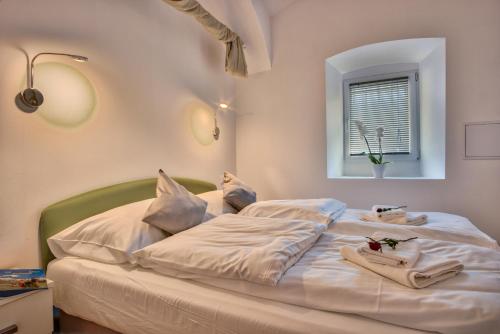 Un dormitorio con una cama blanca con toallas. en Apartment Pod velbi en Liubliana
