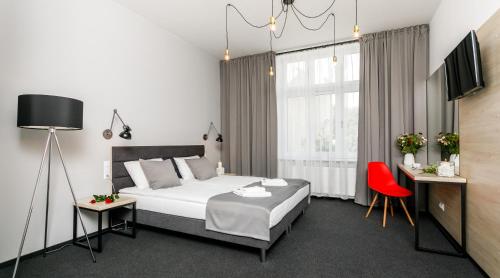 克拉科夫的住宿－Happy Apartments，一间卧室配有一张床和一张红色椅子