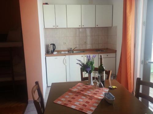 a kitchen with a table with a bottle of wine on it at Studio Apartment Super Odmor in Tučepi