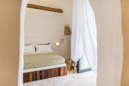 a bedroom with a bed and a window at Borgo Canonica in Cisternino