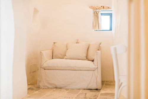 a white chair sitting in the corner of a room at Borgo Canonica in Cisternino
