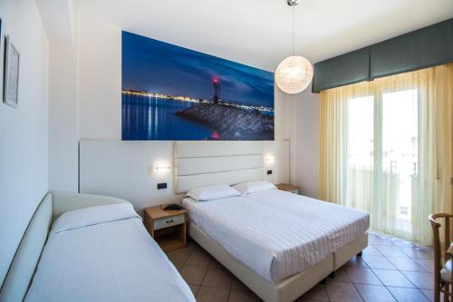 Hotel Palos في ريميني: غرفة نوم بسريرين ولوحة على الحائط