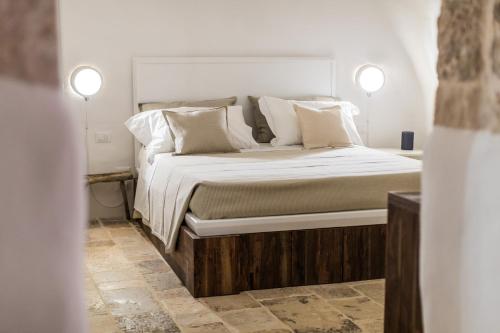 a bedroom with a large bed with white pillows at Borgo Canonica in Cisternino