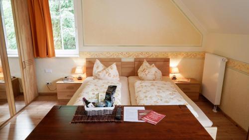 1 Schlafzimmer mit 2 Betten und einem Couchtisch in der Unterkunft Wagners Aparthotel in Sasbachwalden