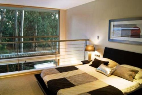 um quarto com uma cama e uma grande janela em SINGLE RENT'APARTMENT em Concepción