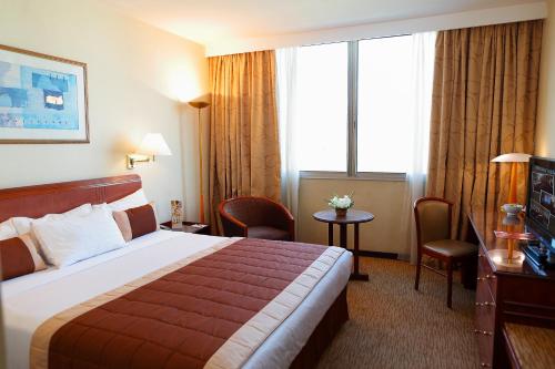 a hotel room with a bed and a large window at Carlton Madagascar in Antananarivo