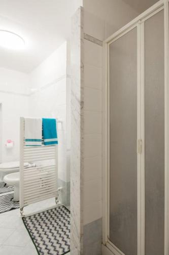 a white bathroom with a shower and a toilet at Casa Beverini in La Spezia