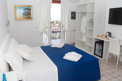 un soggiorno con divano bianco e tavolo blu di Relais Mirage Sorrento a Sorrento