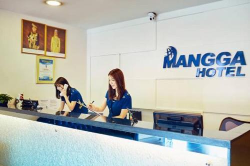 two women sitting at a counter in a hotel at Mangga Boutique Hotel in Seri Kembangan