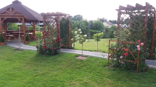 a garden with a pavilion and a gazebo with roses at Hotel Restauracja LORENZO in Stopnica