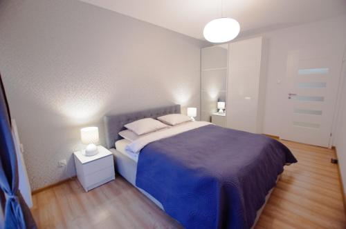 コウォブジェクにあるApartament Blue Coast Solna 11c/305のベッドルーム1室(大型ベッド1台、青いベッドカバー付)