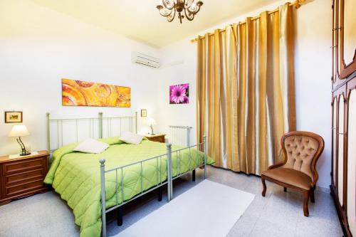 - une chambre avec un lit vert et une chaise dans l'établissement Mare e Montagna, à Villa San Pietro