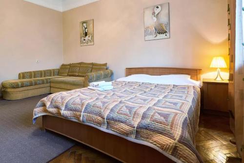 ein Schlafzimmer mit einem großen Bett und einem Sofa in der Unterkunft Home Hotel Apartments on Lva Tolstogo in Kiew