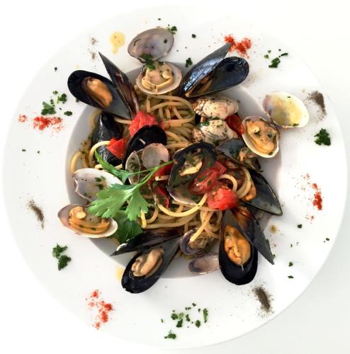 a plate of pasta with mussels and seafood at Paradiso Terme Resort & SPA con 5 piscine termali in Ischia