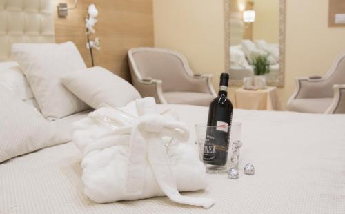 - Botella de vino y toalla en la cama en Esposizione Palace Hotel, en Roma
