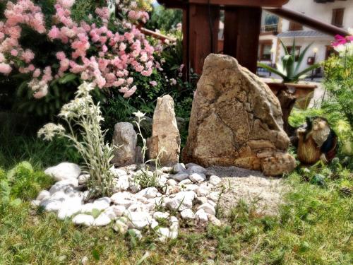 a garden with rocks and flowers in a yard at Hotel al Sole in Auronzo di Cadore