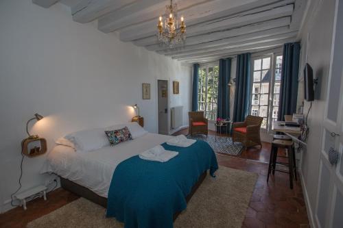 - une chambre avec un lit et une couverture bleue dans l'établissement Berceau Henri II, au Mans