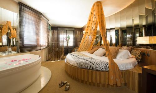 a bedroom with a bed and a tub in a room at Hotel il Castelletto in Casarile