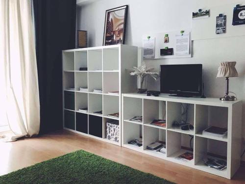 a white book shelf with a television on it at Griffn Properties Flora in Essen