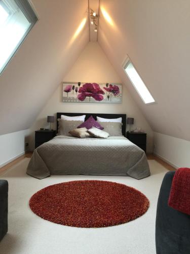 a attic bedroom with a bed with a red rug at Bed & Breakfast Kortenhoefsedijk in Kortenhoef